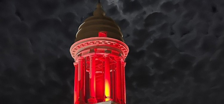 La luce rossa della speranza riflette sulla Torre dell’Orologio